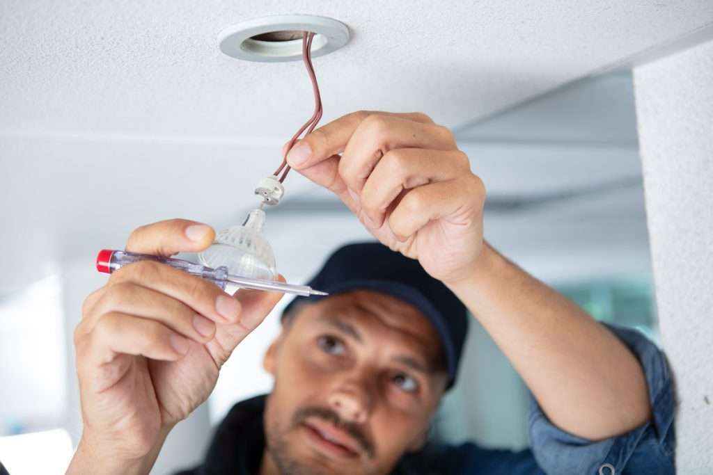 electrician installing led lighting to the ceiling