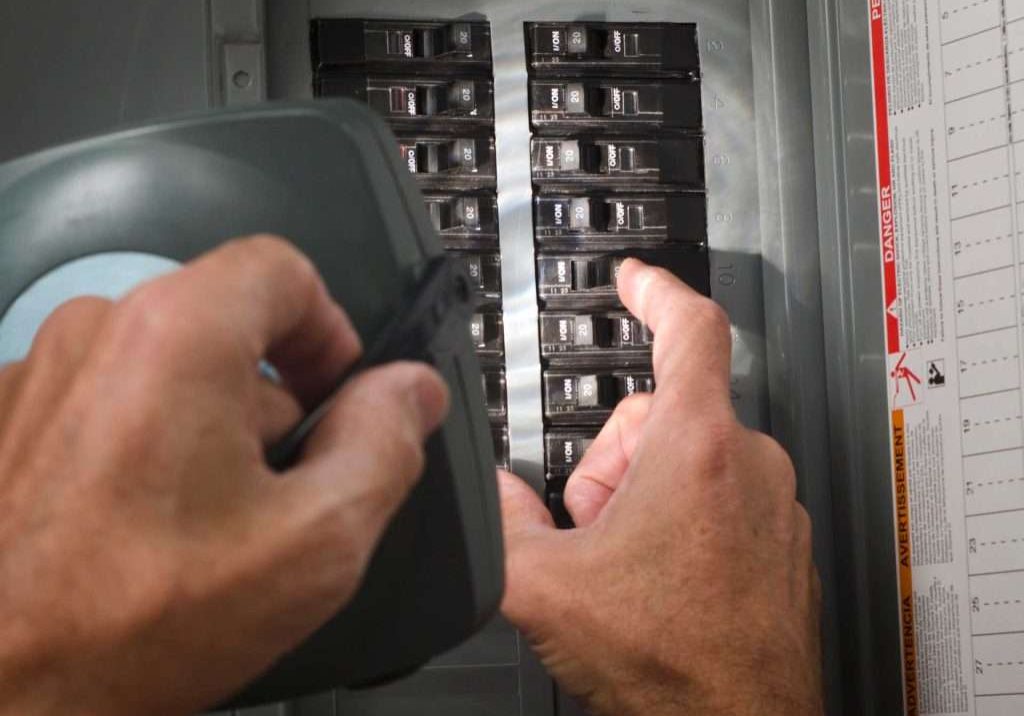 Electrician checking the electrical load of a homeowner's electrical panel in Seattle.