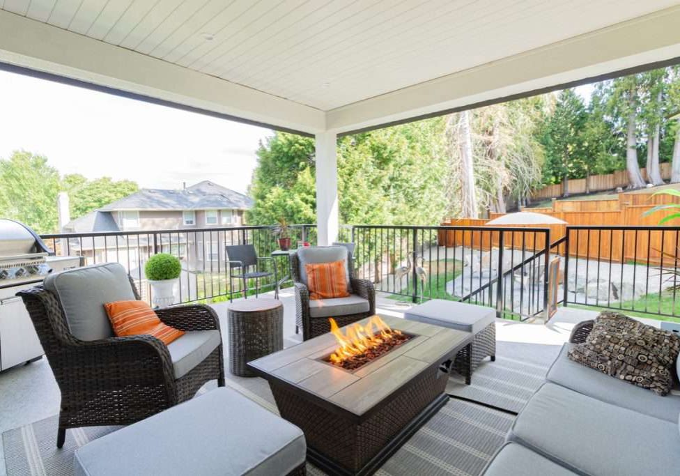 A spacious deck with a fire pit table heater