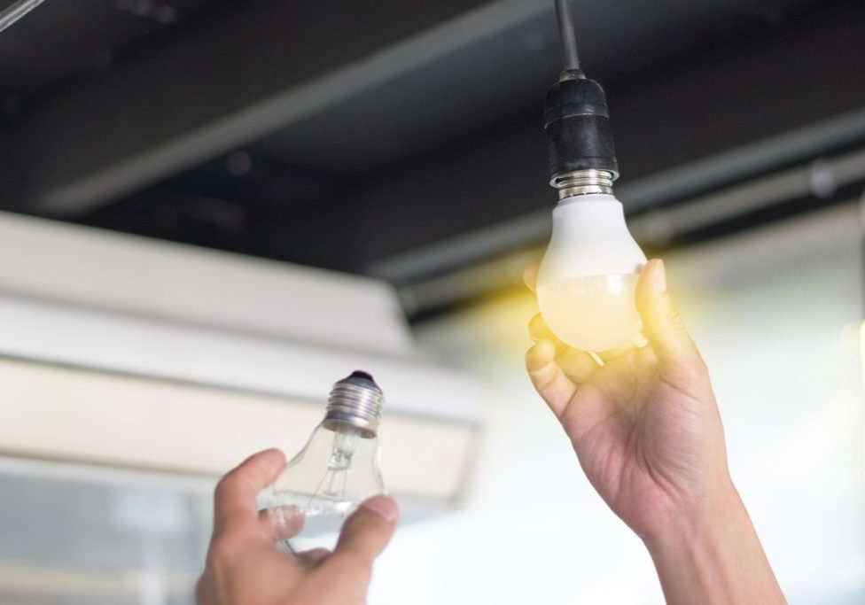 Changing out a light bulb with energy efficient LED light bulb